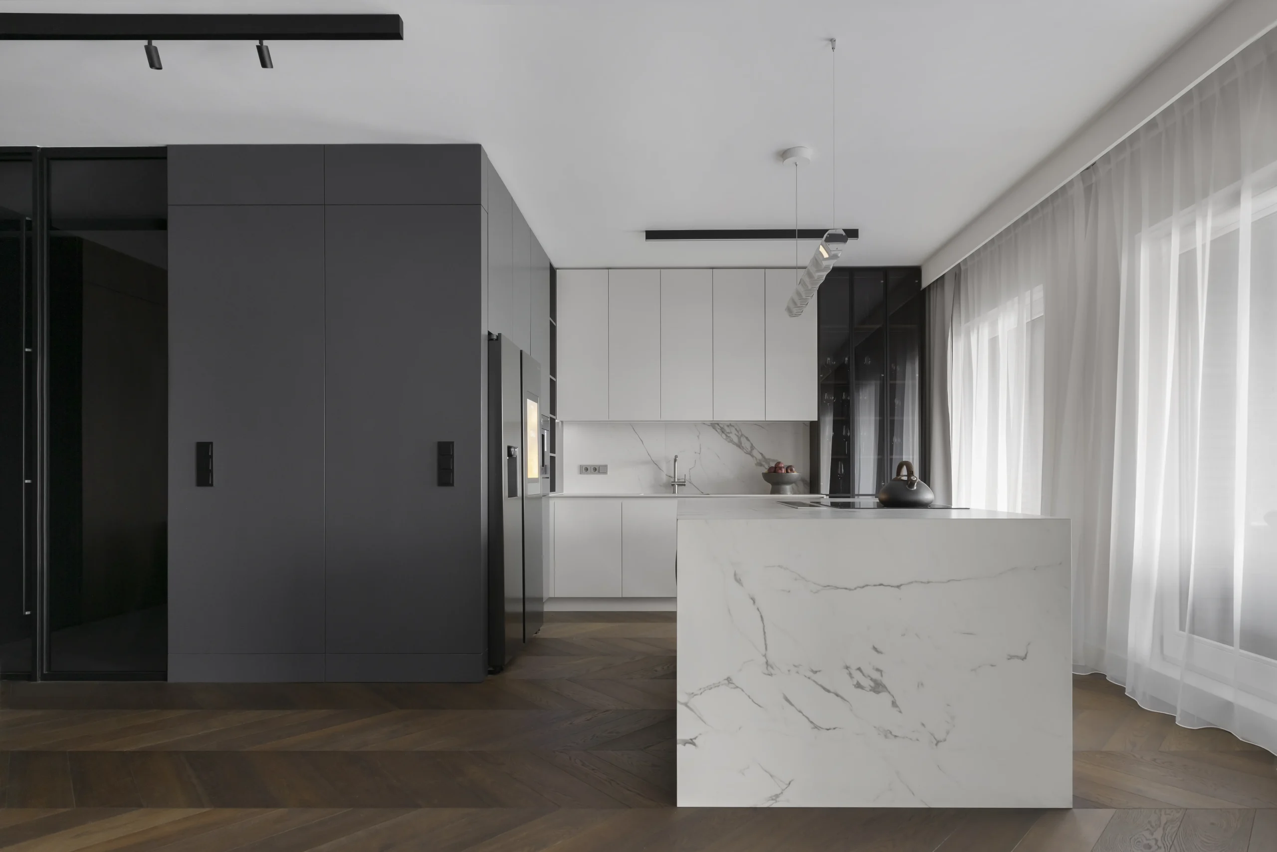 Kuchnia w apartamencie w Gdańsku – białe meble i wyspa z marmurowym blatem – AXMN Gdańsk