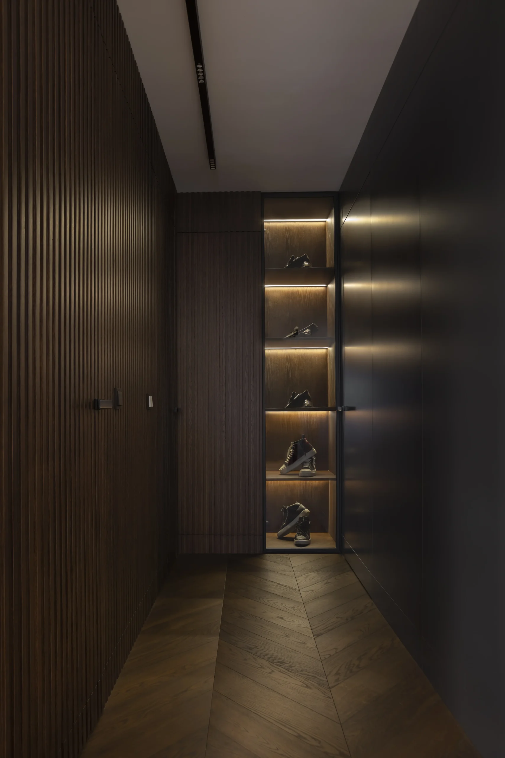 Korytarz apartamentu w Gdańsku z podświetloną garderobą – projekt AXMN Gdańsk