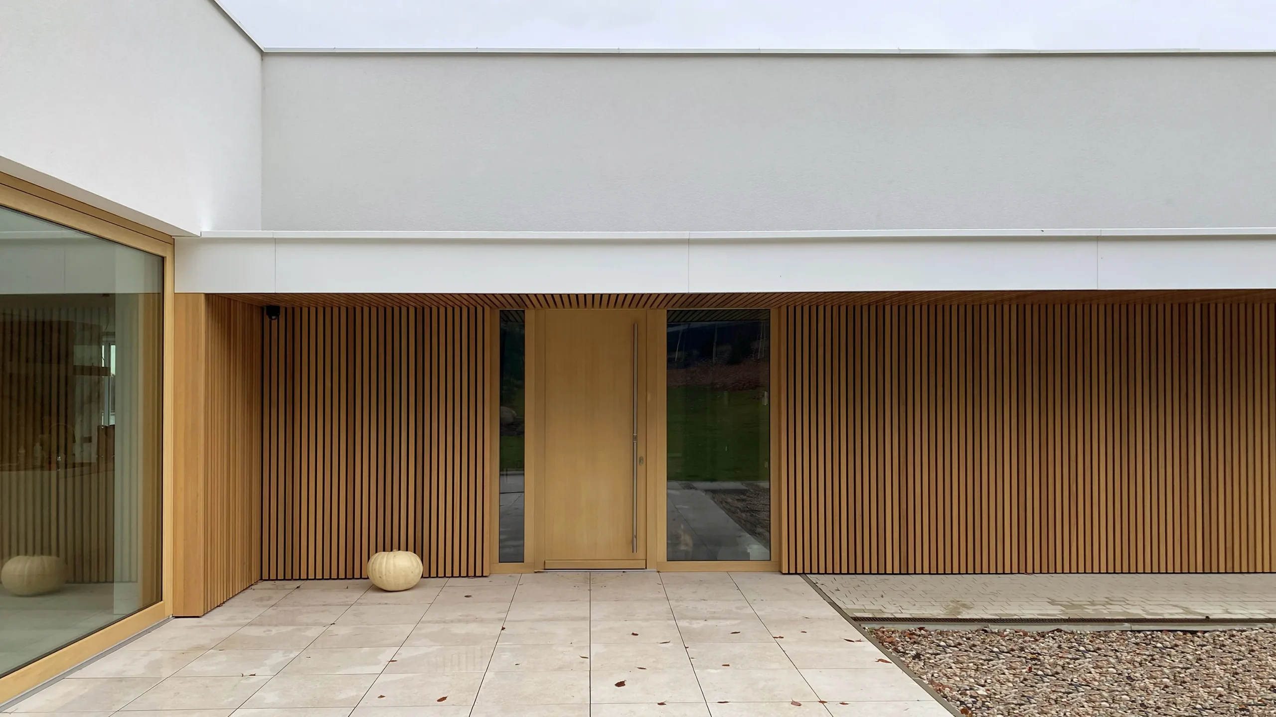 Dom nad jeziorem Mausz – wejście do domu z drewnianą elewacją – AXMN Gdańsk