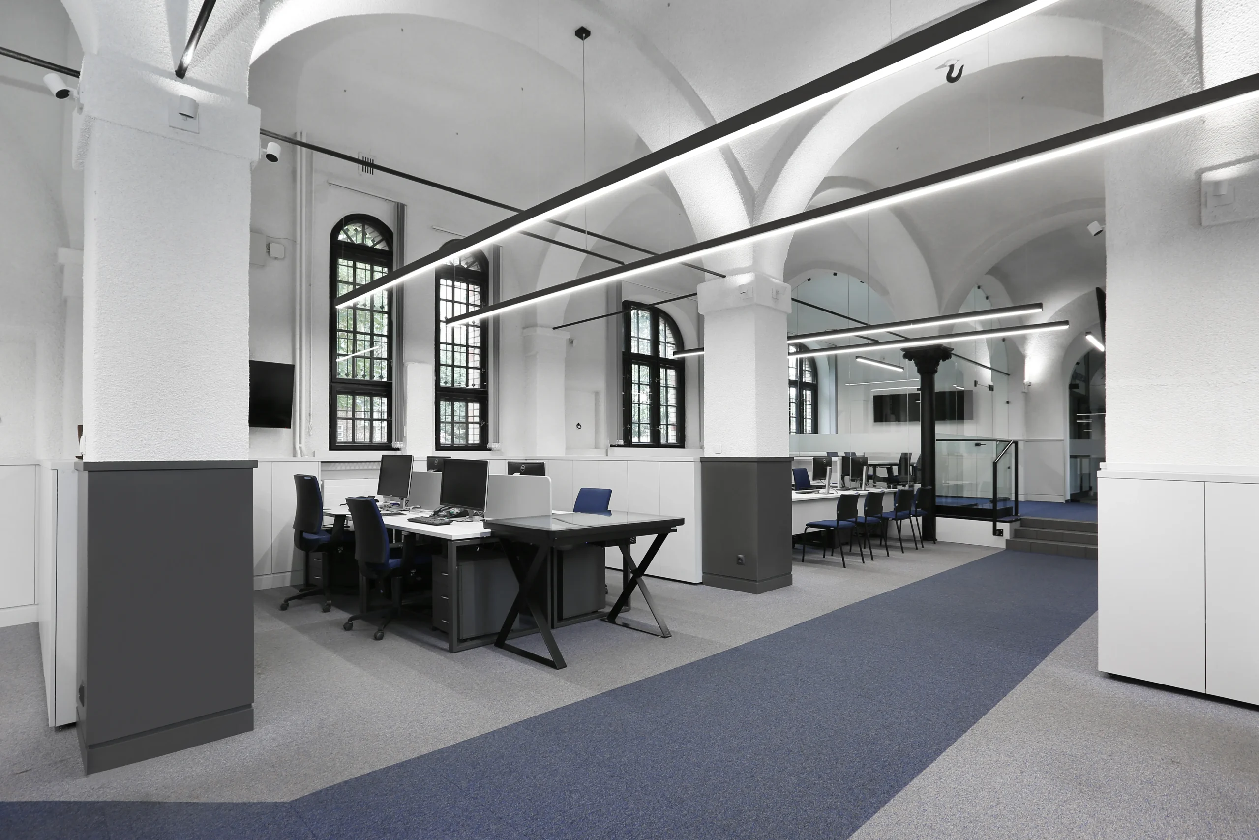 Biuro Saur Neptun Gdańsk – przestrzeń pracy z wysokim sklepieniem i czarnymi słupami