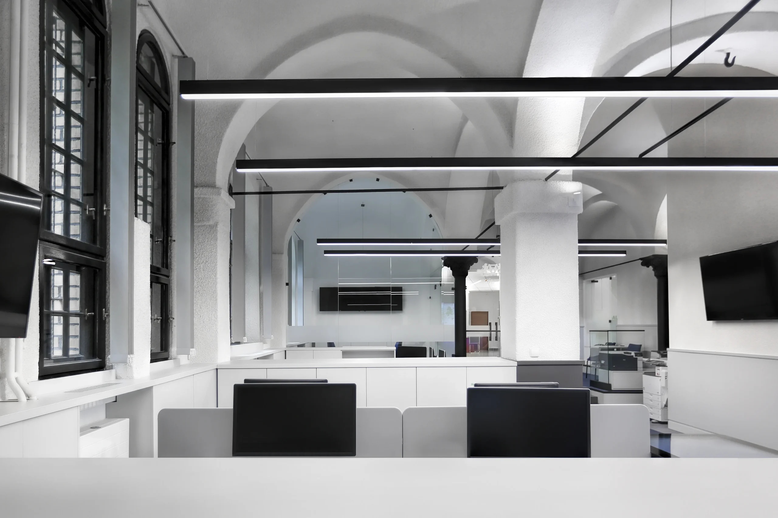 Nowoczesna przestrzeń biurowa z białymi biurkami i łukowymi sklepieniami – Saur Neptun Gdańsk